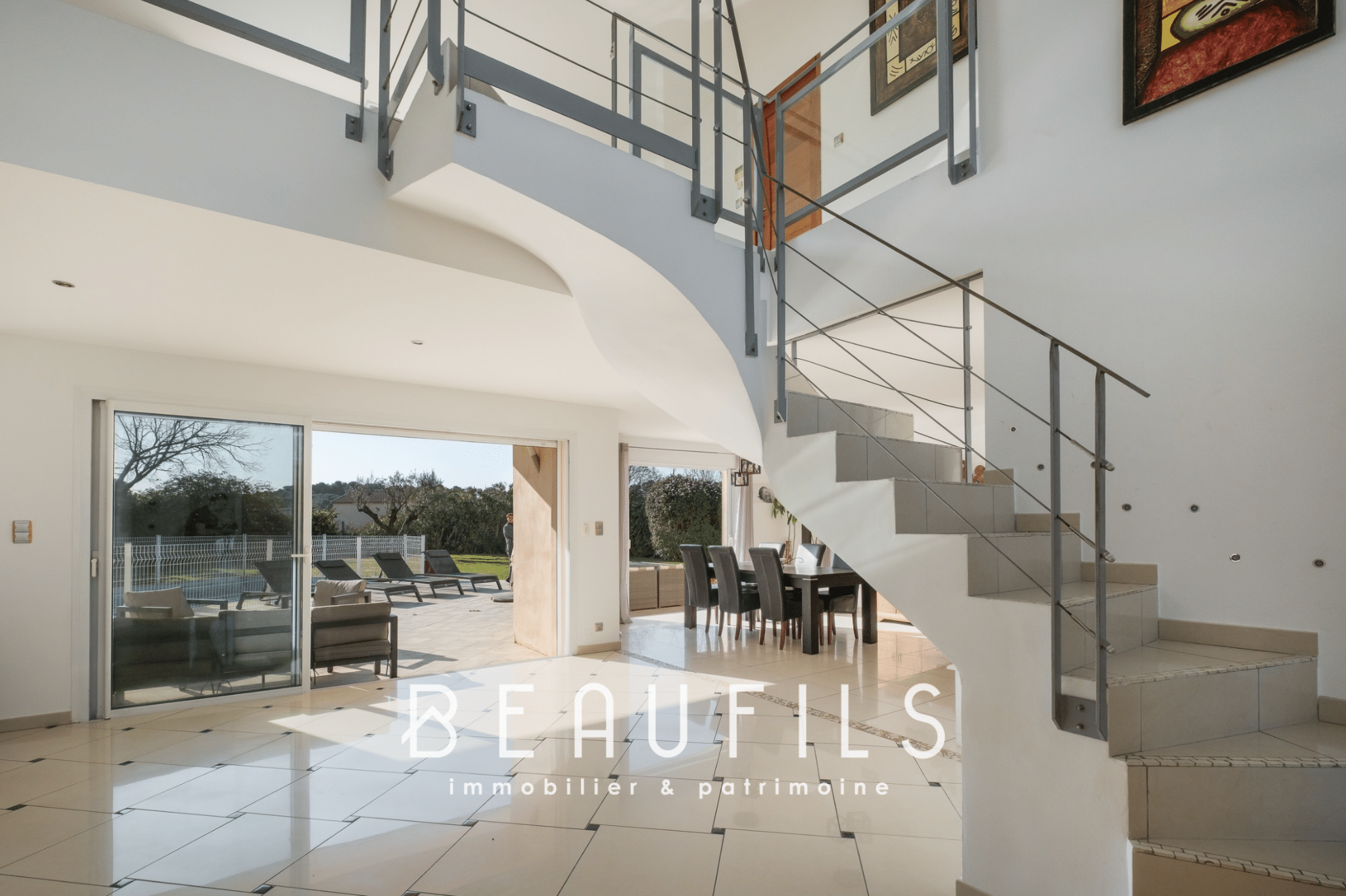 Interior of a modern architect-designed villa with staircase and large open-plan living area opening onto the outside.