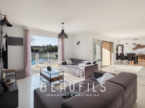 Interior of a modern villa with living room, open kitchen and access to the outside.