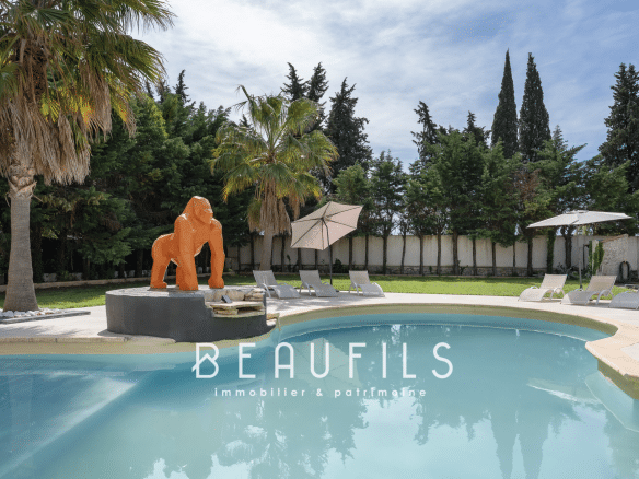 Swimming pool with outdoor gorilla sculpture, surrounded by palm trees and green space.