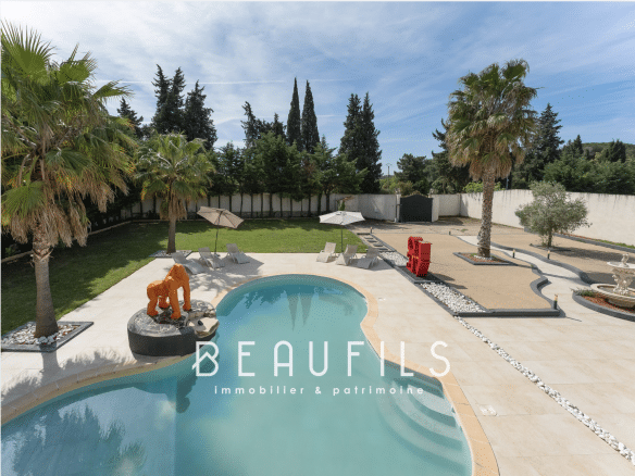 View of a neo-Provençal farmhouse with swimming pool and garden in Saint-Gilles, Nîmes.