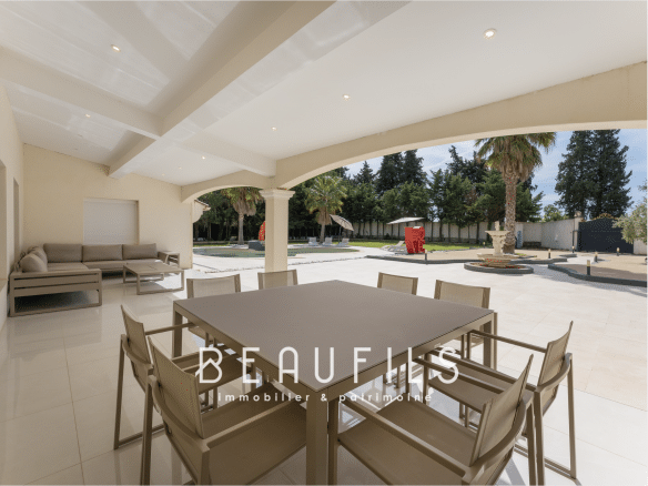 Spacious terrace of a neo-Provençal farmhouse in Saint-Gilles, with modern furniture and swimming pool.