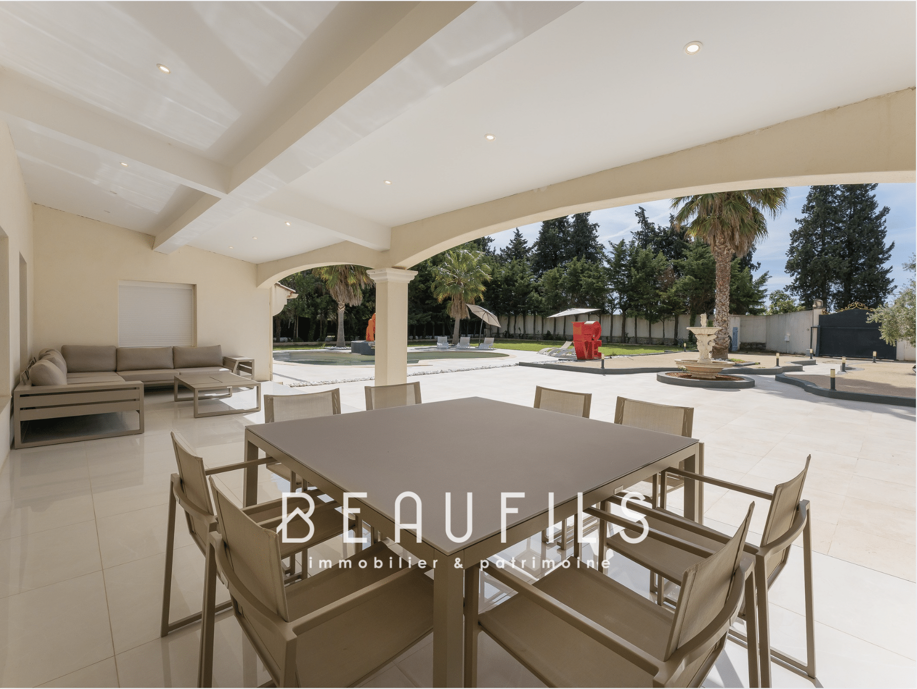Spacious terrace of a neo-Provençal farmhouse in Saint-Gilles, with modern furniture and swimming pool.