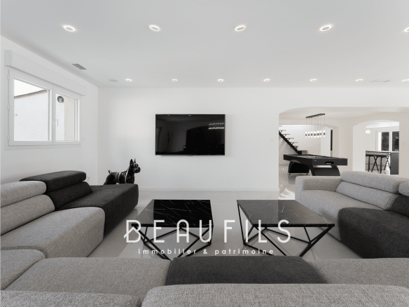 Interior of a renovated neo-Provençal farmhouse with a modern living room and billiard area.