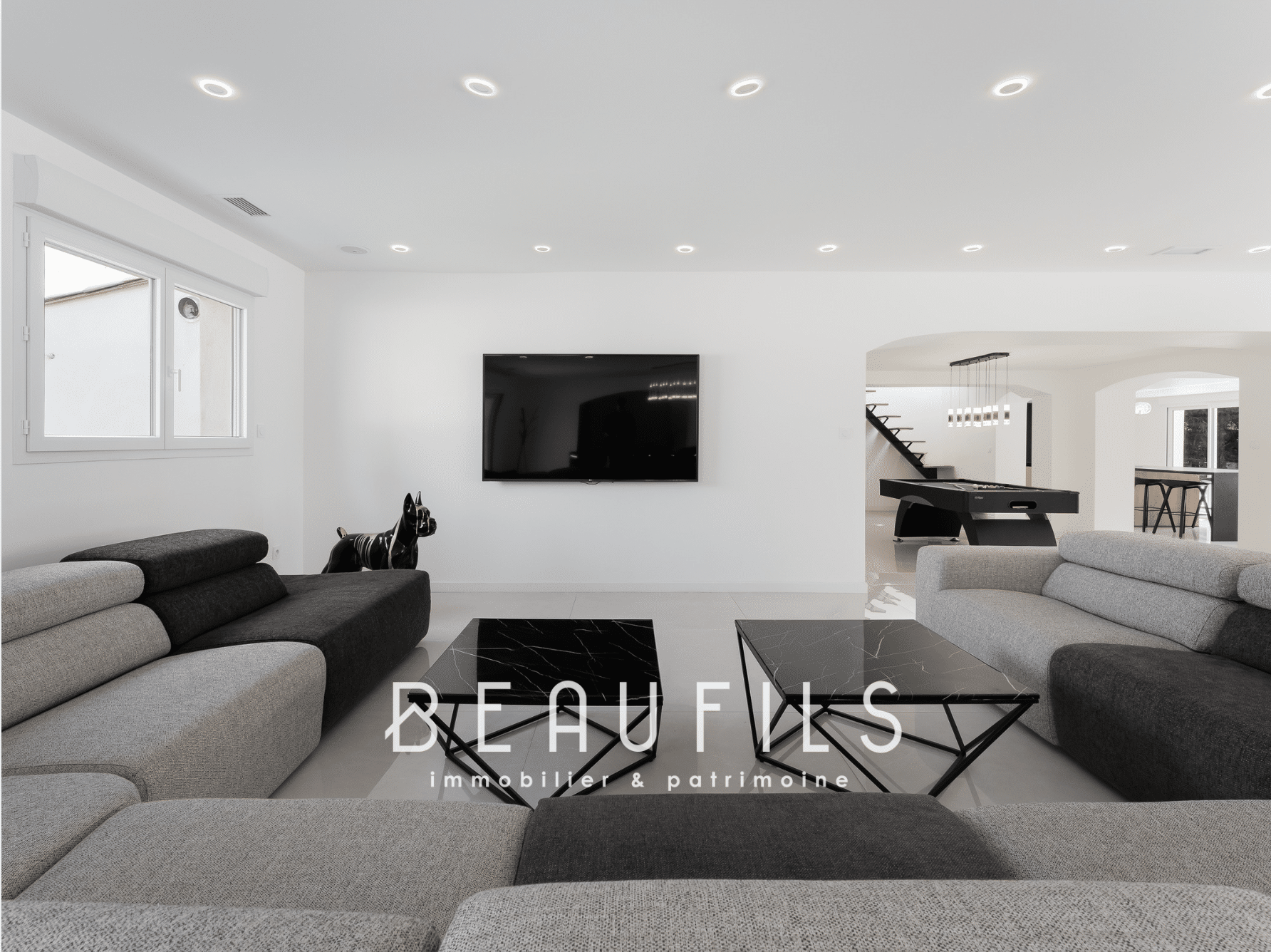 Interior of a renovated neo-Provençal farmhouse with a modern living room and billiard area.