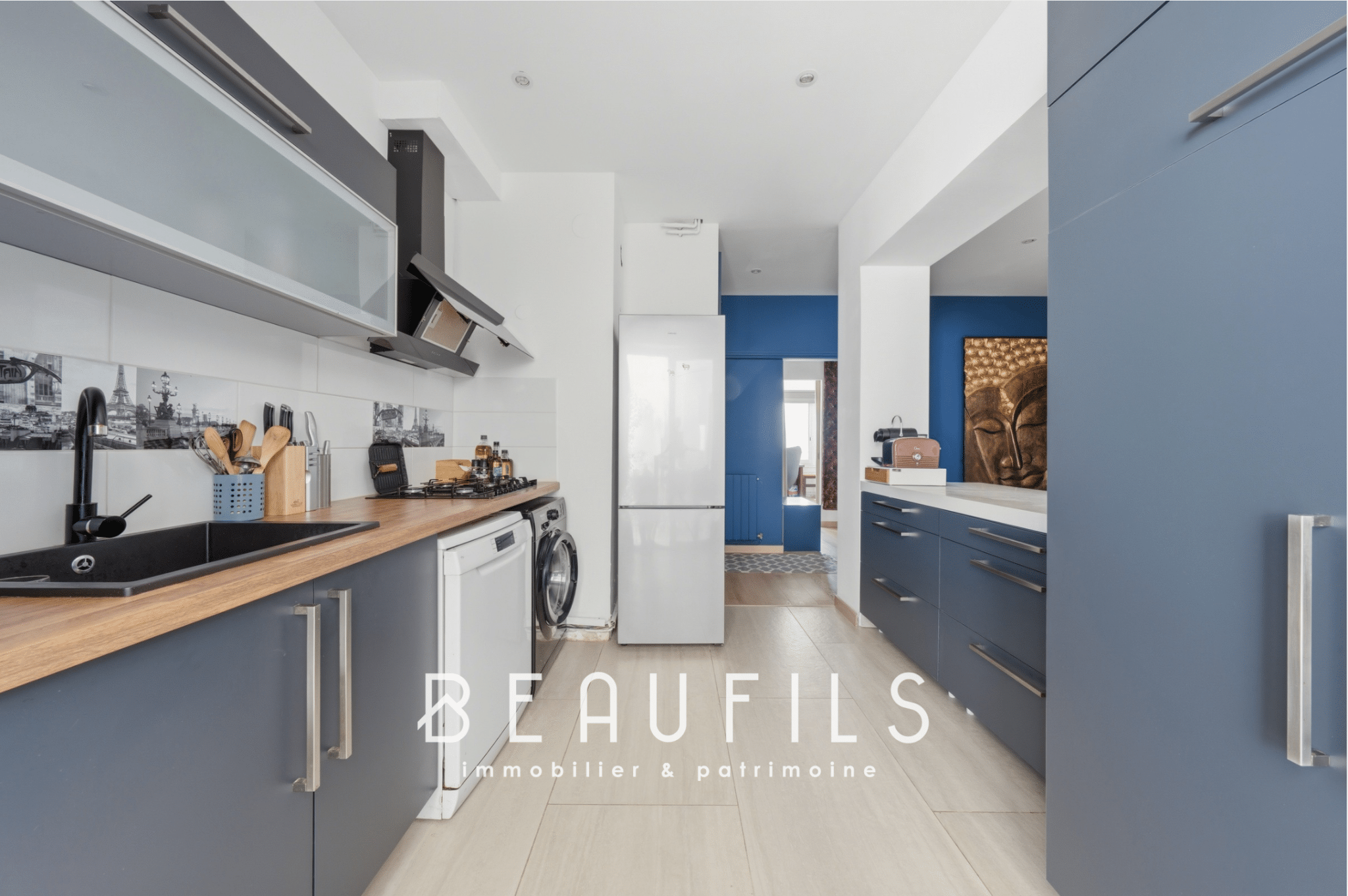 Modern kitchen in a renovated apartment with grey furniture and a wooden worktop.