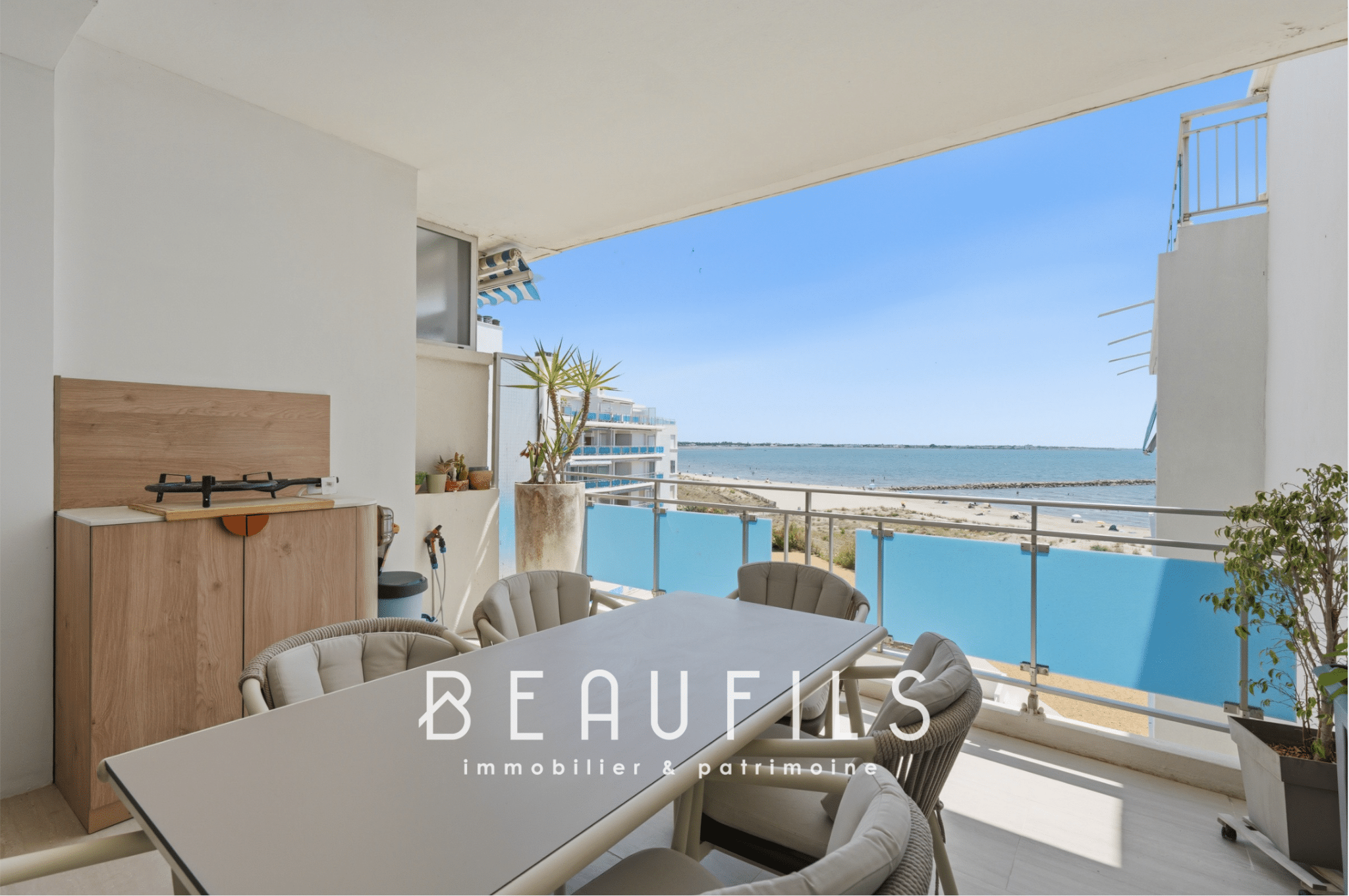 Terrace of an apartment with sea view in Le Grau-du-Roi, modern furniture and dining table.