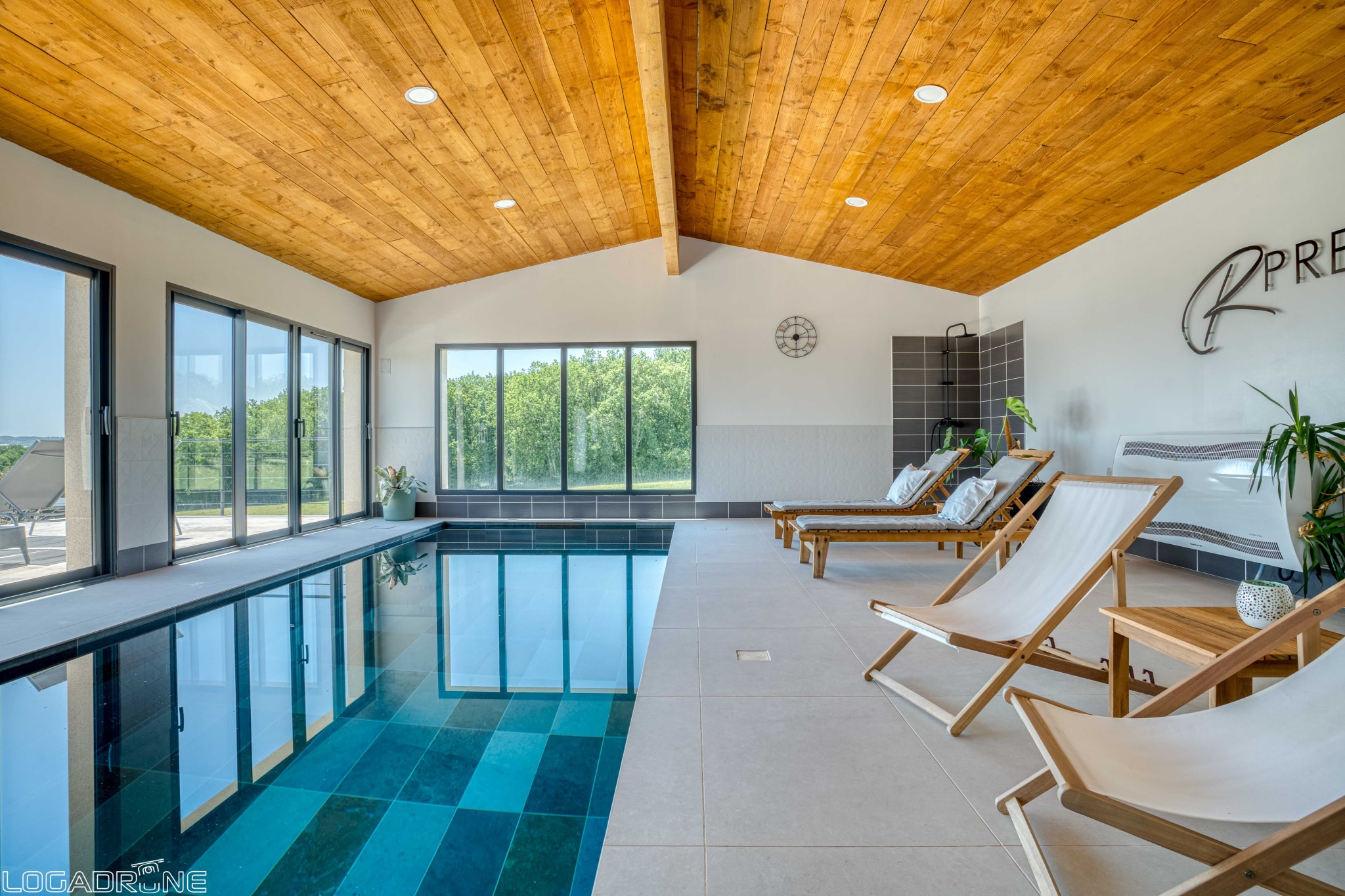 Interior of a renovated stone property with swimming pool and sun loungers, overlooking the countryside.