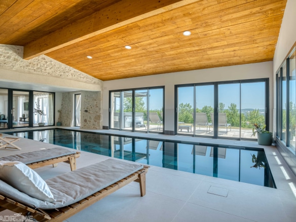 Interior of a renovated stone property with swimming pool and countryside views in Le Lédat.