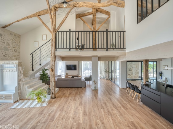 Interior of a renovated stone property with a large living space and a mezzanine.