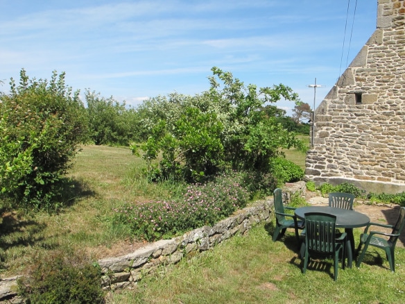 Jardin d'une propriété historique avec des chaises et une table en extérieur à Pont-l'Abbé.