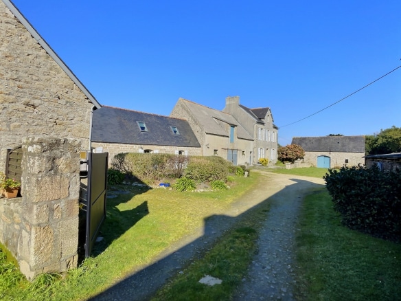Corps de ferme historique du XVIIIe siècle à Pont-l'Abbé, en Cornouaille, avec un chemin d'accès et des bâtiments en pierre.