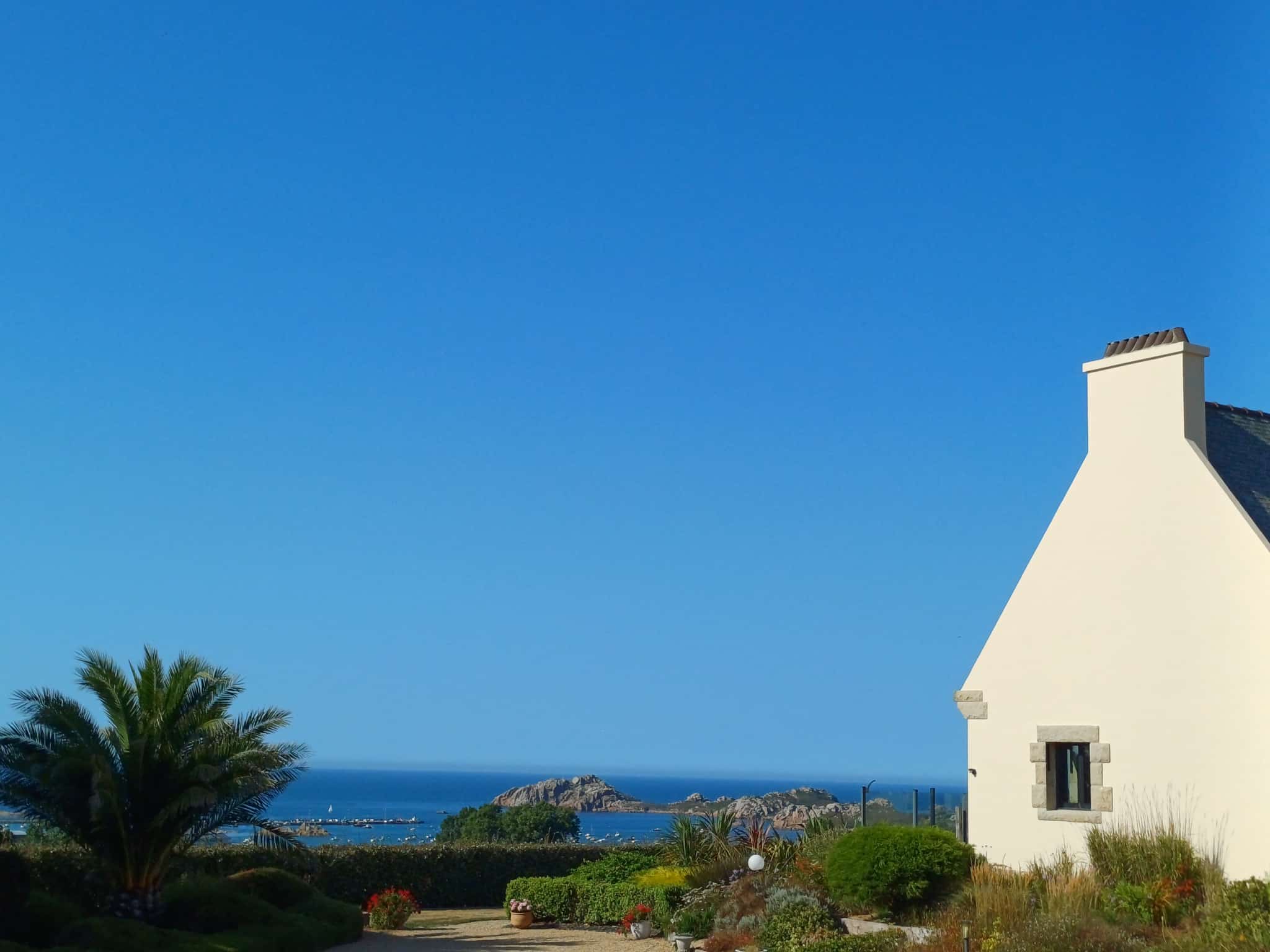 House with sea view in Plougasnou, garden and clear sky.