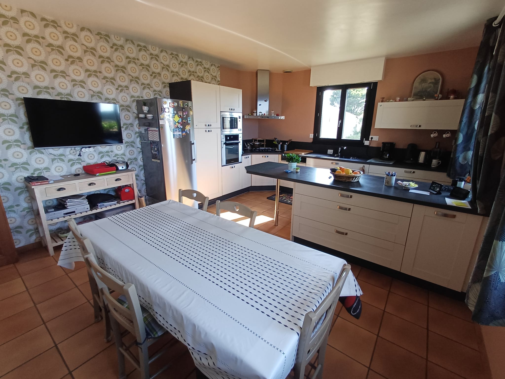 Interior of a modern kitchen with dining table and household appliances.