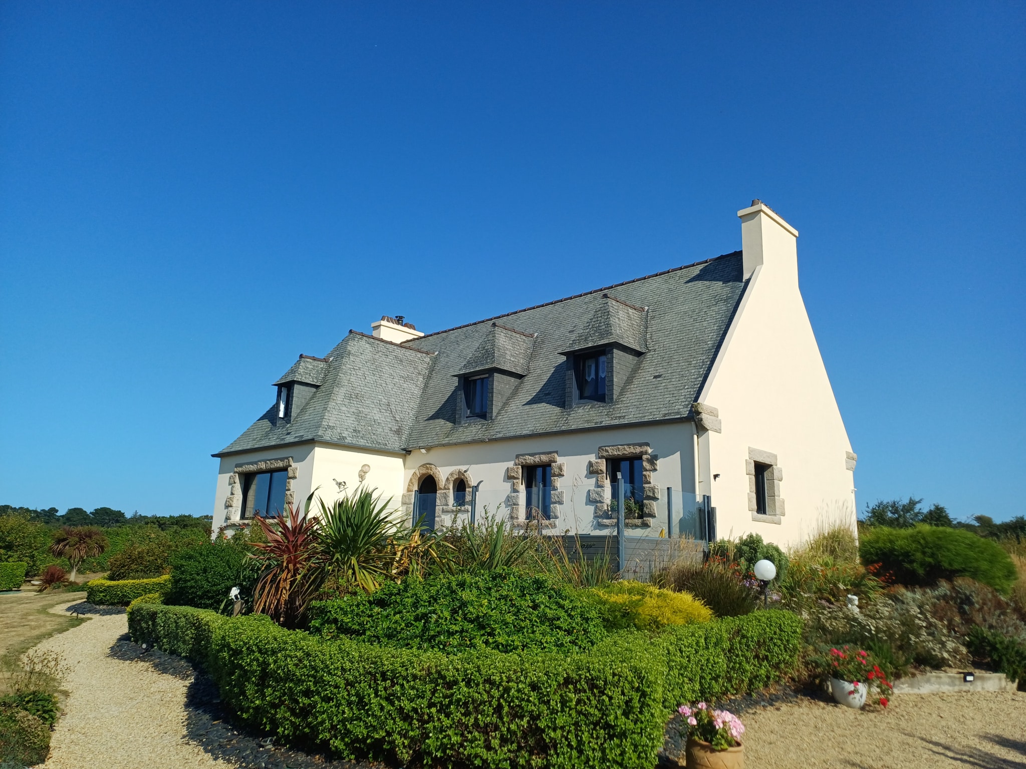 House with sea view in Plougasnou, surrounded by greenery and garden.
