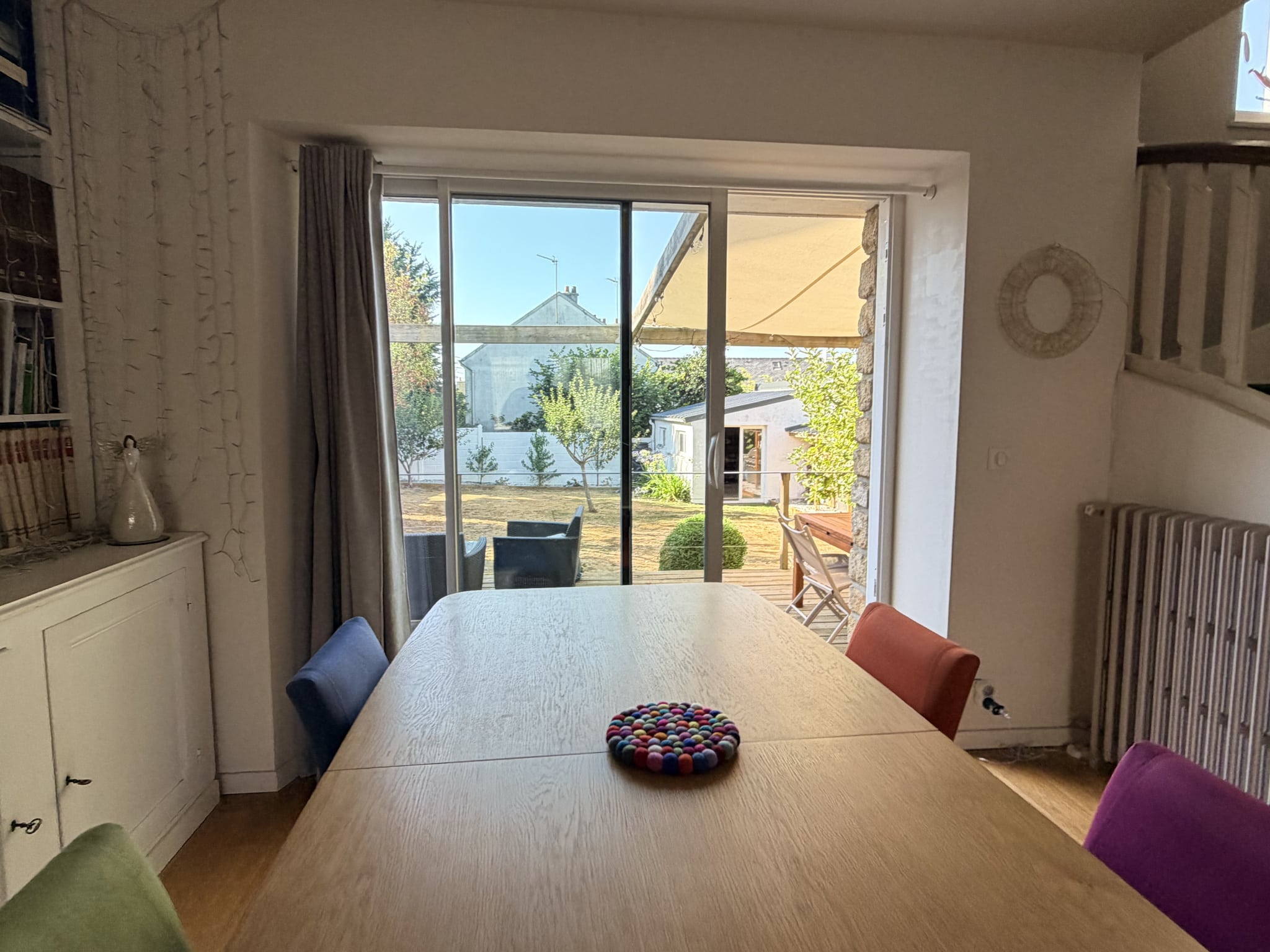 Intérieur d'une maison à Auray avec une grande fenêtre donnant sur un jardin.