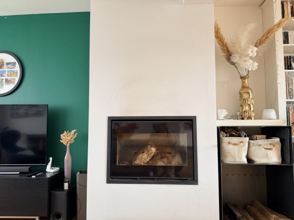 Intérieur d'un salon moderne avec cheminée, télévision et décoration élégante.