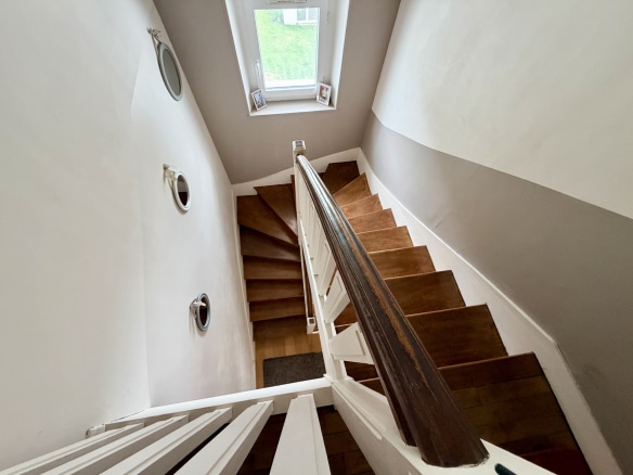 Escalier en bois menant à un étage supérieur dans une maison à Auray.