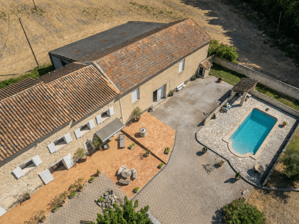 Vue aérienne d'un mas en pierre avec piscine et terrasse, situé en campagne près de L'Isle-sur-la-Sorgue.