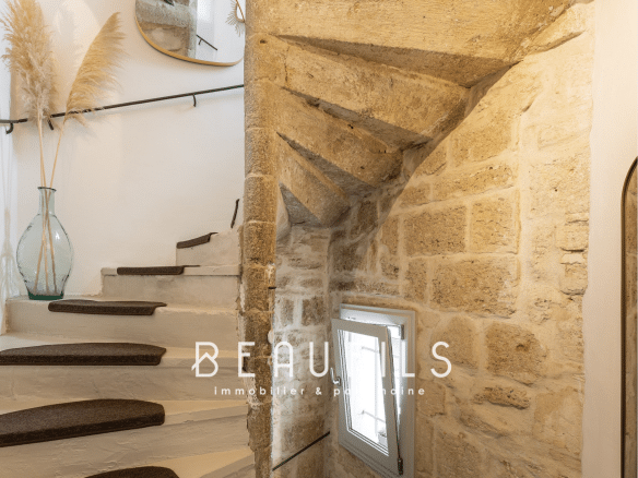 Escalier en pierre avec rampe noire et décoration intérieure moderne dans une maison à Montpellier Écusson.