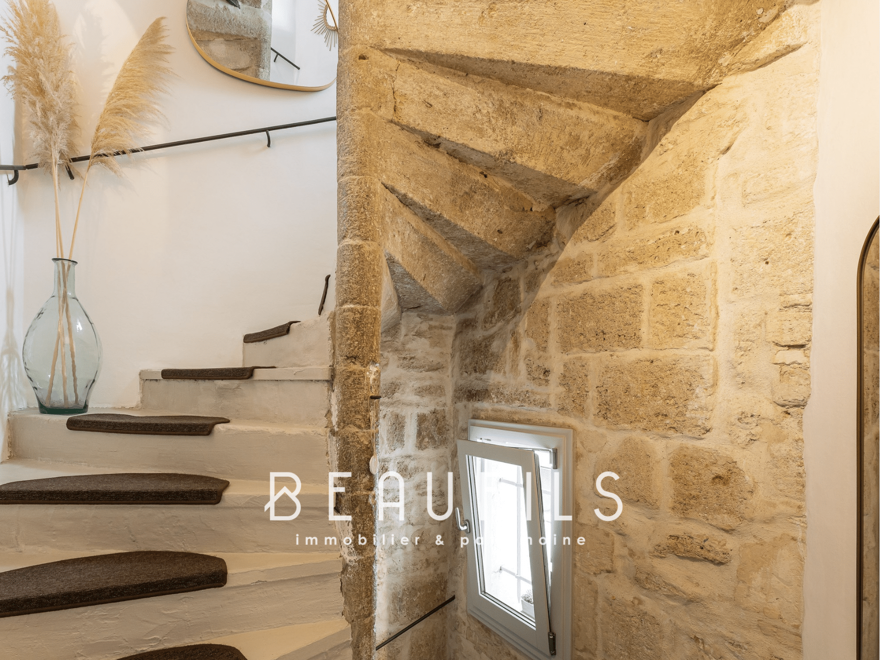 Escalier en pierre avec rampe noire et décoration intérieure moderne dans une maison à Montpellier Écusson.