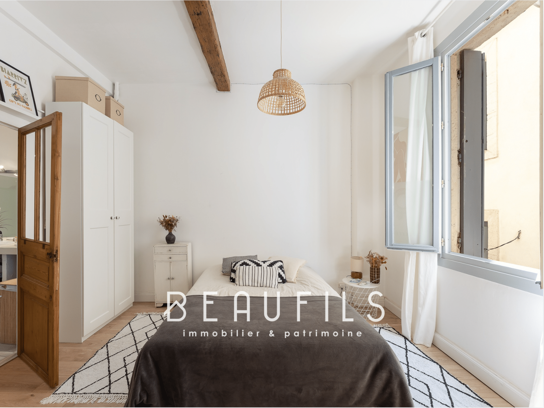 Chambre lumineuse d'une maison rénovée à Montpellier, avec fenêtre ouverte et décoration minimaliste.