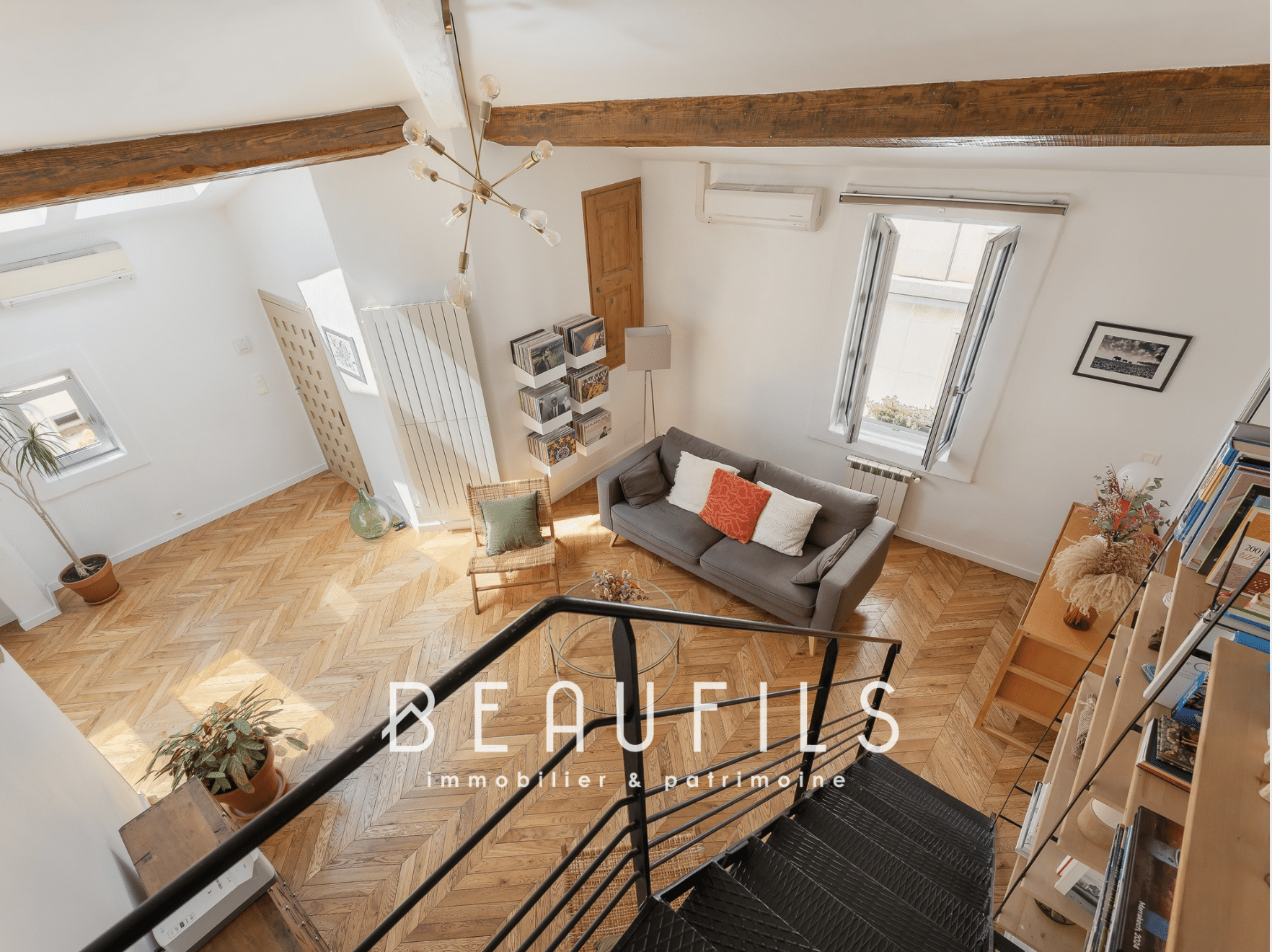 Intérieur d'une maison rénovée à Montpellier avec un salon lumineux et un escalier en bois.