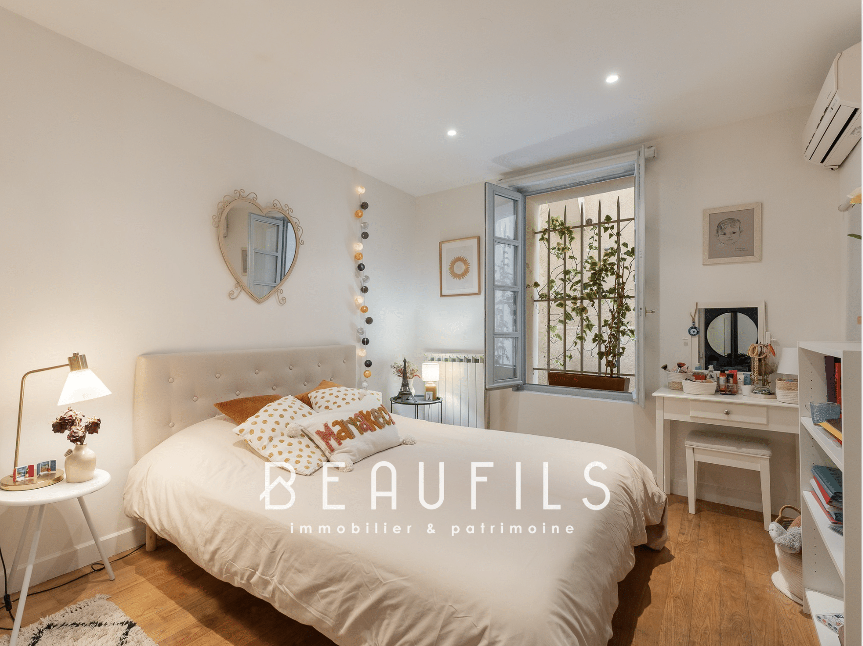 Chambre d'une maison rénovée à Montpellier avec lit, bureau et fenêtre donnant sur l'extérieur.