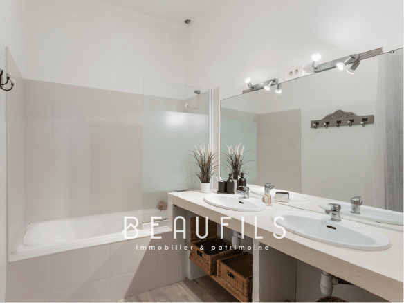 Salle de bain moderne avec baignoire et double vasque dans une maison rénovée à Montpellier Écusson.