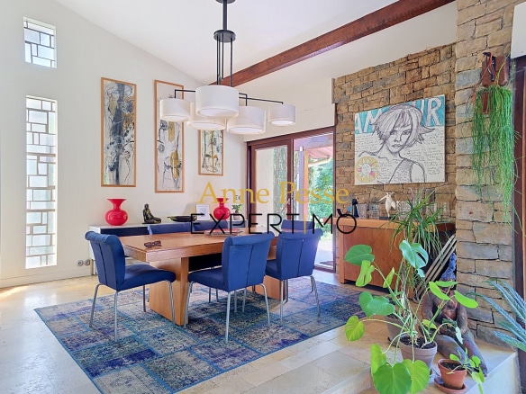 Interior of a modern villa with a dining room, artwork and plants.