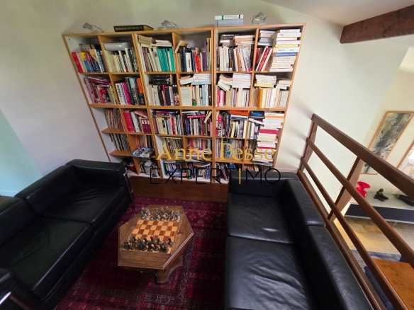 Interior of a modern architect-designed villa with bookshelves filled with books and a comfortable living room.
