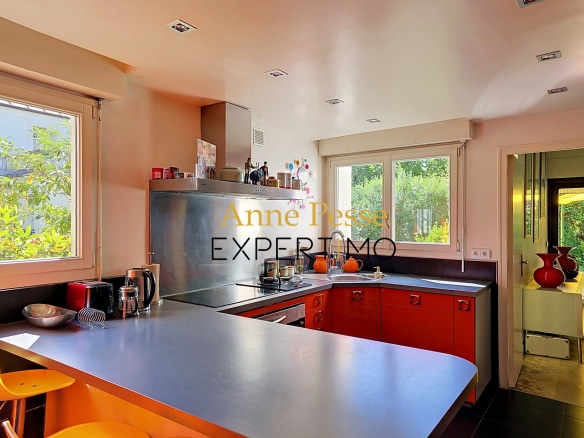 Modern kitchen in an architect-designed villa in Saint-Maur-des-Fossés, with a bar and windows overlooking the outside.