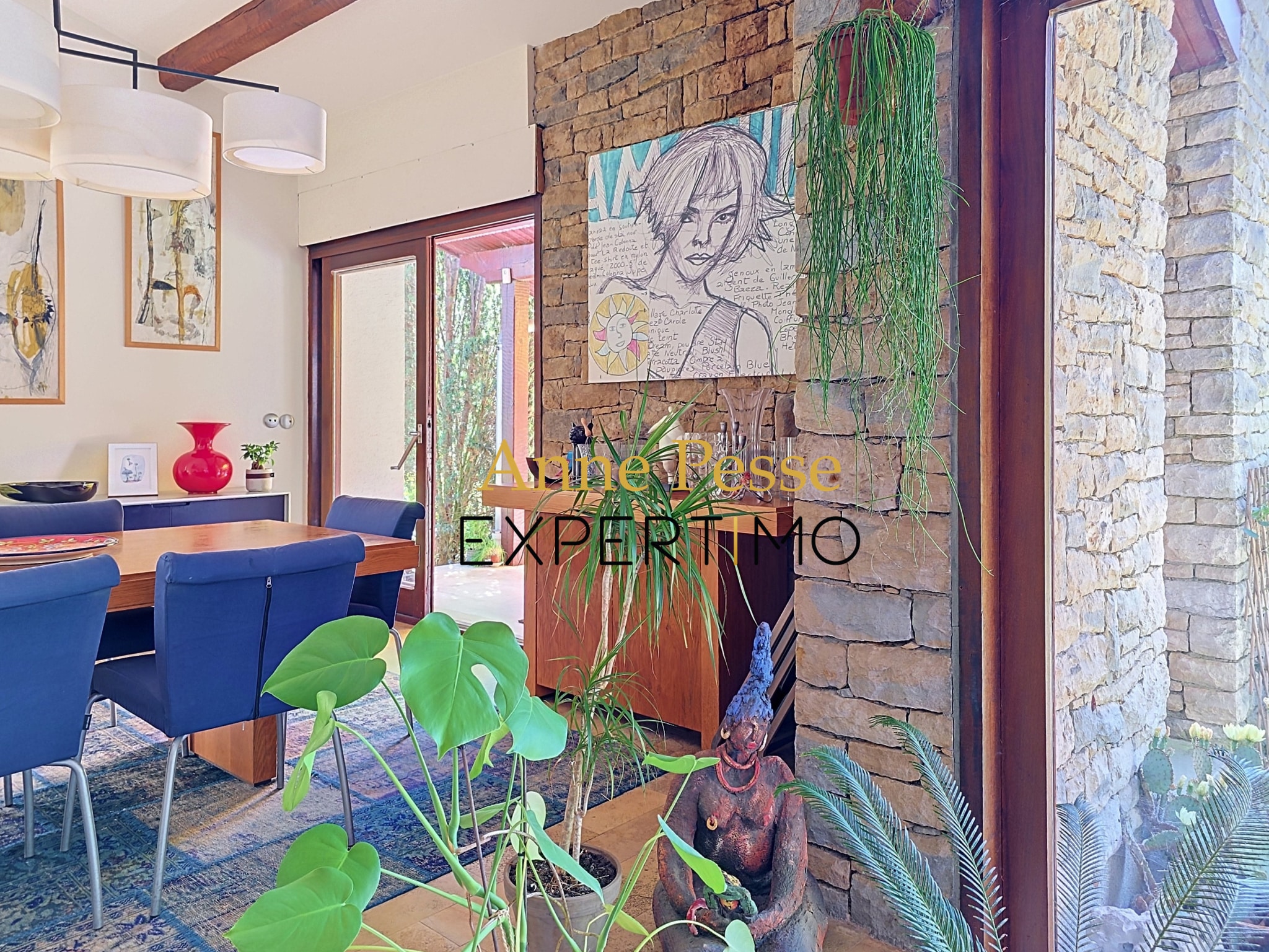 Interior of a modernist architect's villa with plants and a work of art on the wall.