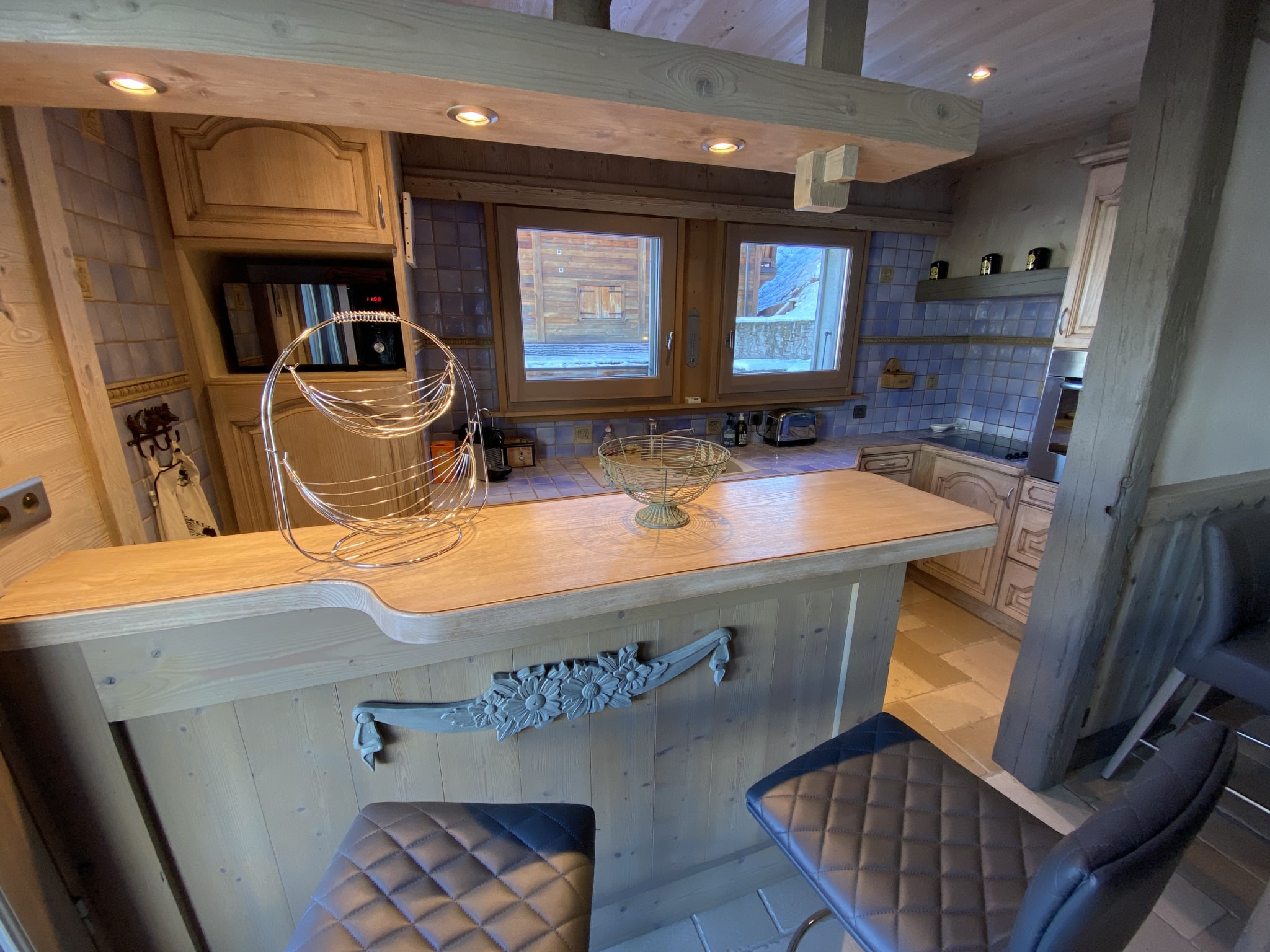 Modern and welcoming kitchen in a renovated apartment in Megève, with bar and integrated equipment.