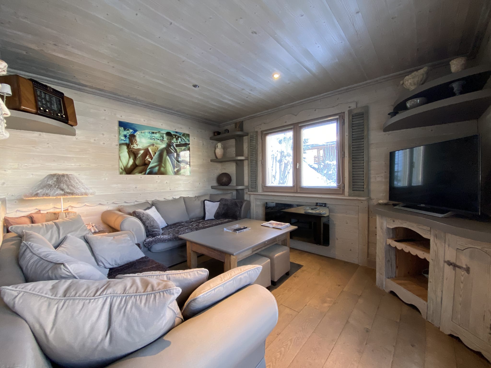 Living room of a renovated apartment with comfortable sofa and light wood decor.