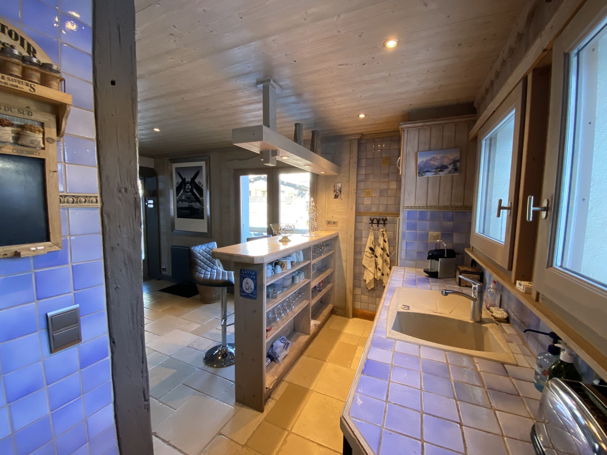 Renovated kitchen with blue tiles and wooden worktop in an apartment in Megève.