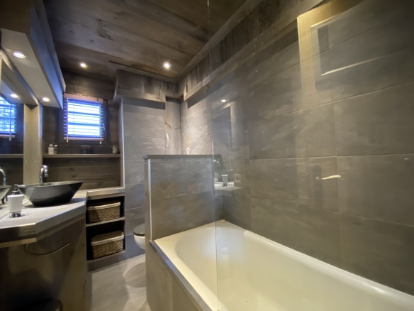 Modern bathroom with bathtub and sink in a renovated apartment in Megève.
