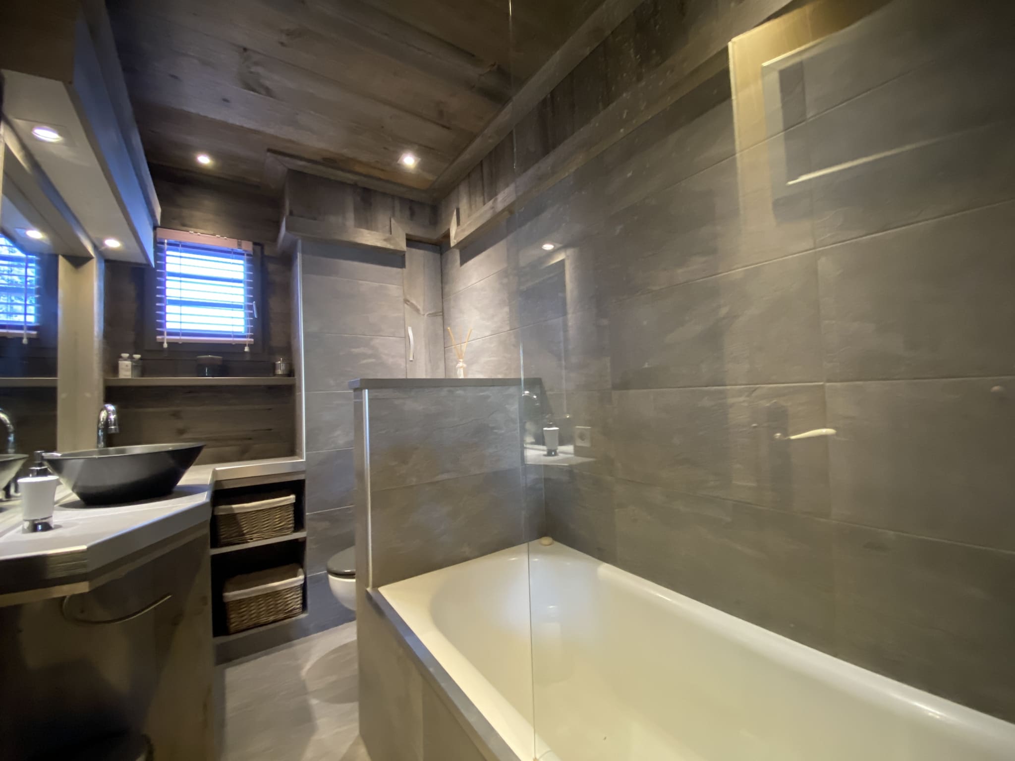 Modern bathroom with bathtub and sink in a renovated apartment in Megève.