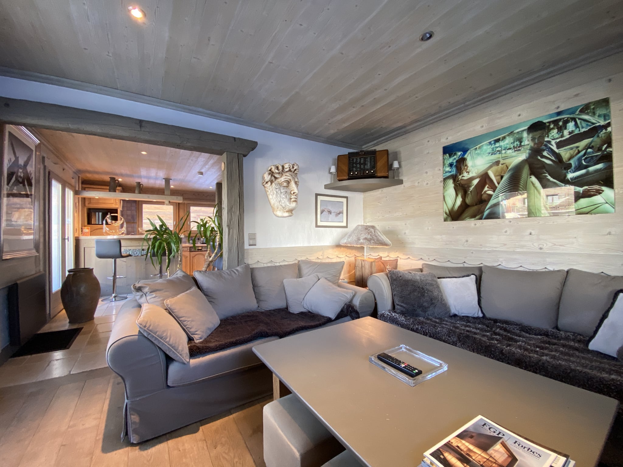 Living room of a beautifully renovated apartment in Megève, with comfortable sofa and wooden decor.