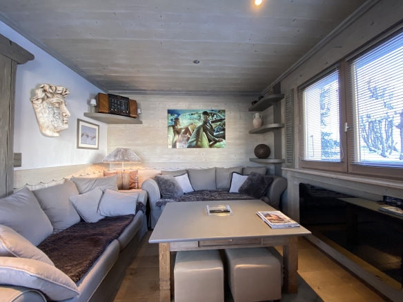 Cozy living room in a renovated apartment with sofa and coffee table, windows with a view of the snow.