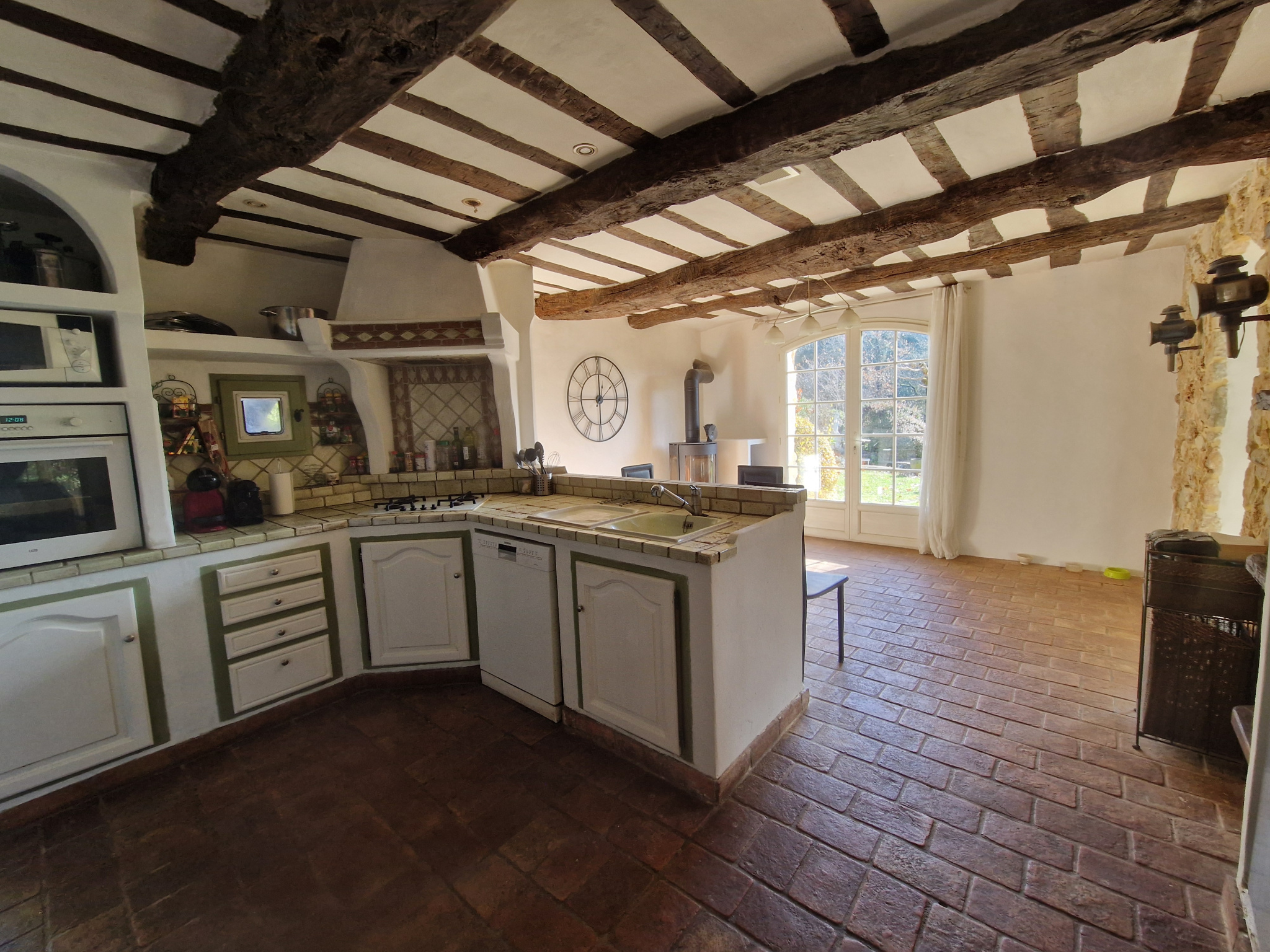 Cuisine d’une bastide provençale Intérieur d'une cuisine provençale avec poutres apparentes et carrelage en terre cuite.