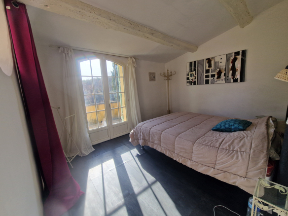 Chambre lumineuse avec lit double et fenêtre donnant sur l'extérieur.