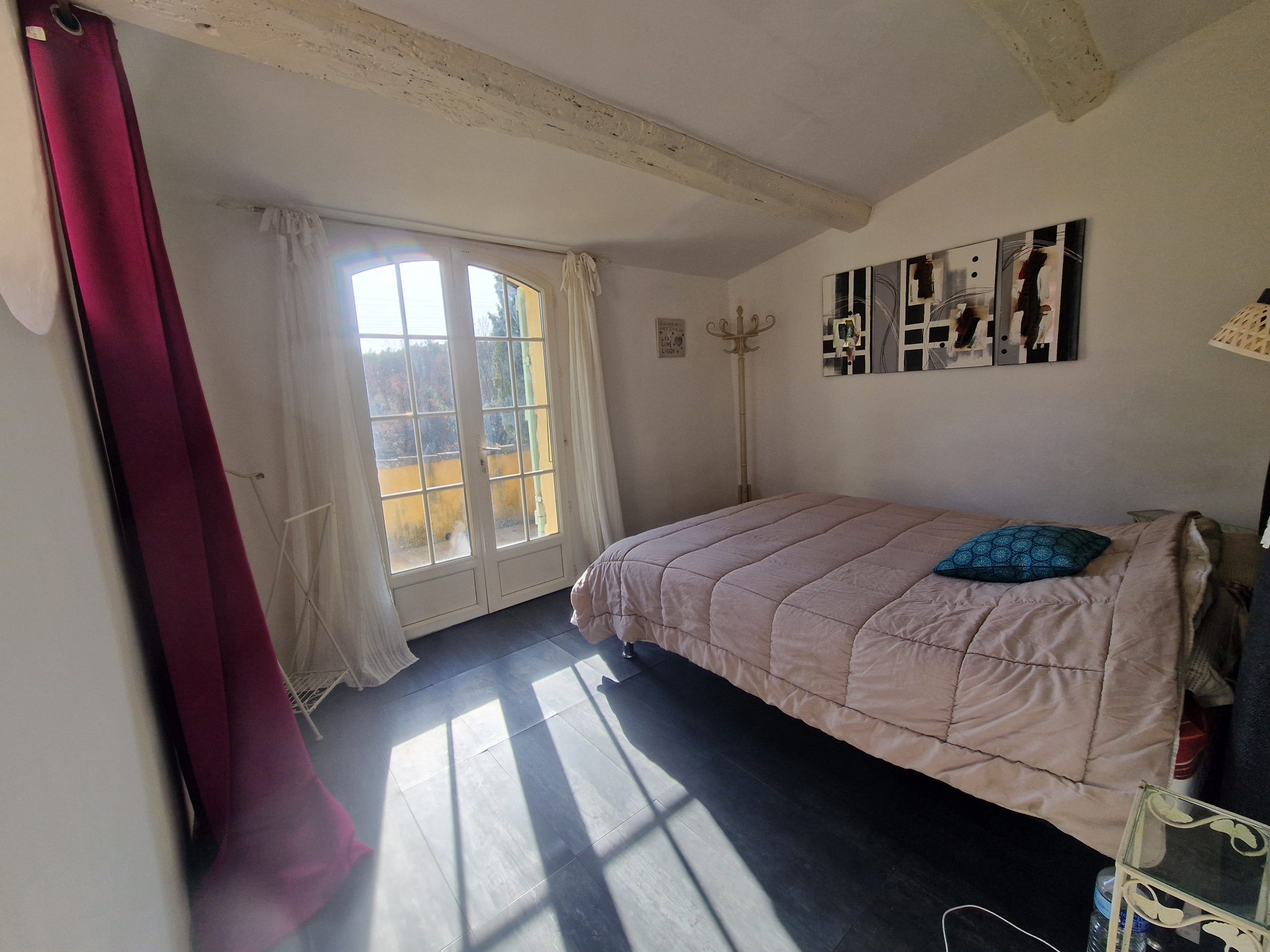 Chambre d’une bastide à Lorgues Chambre lumineuse avec lit double et fenêtre donnant sur l'extérieur.