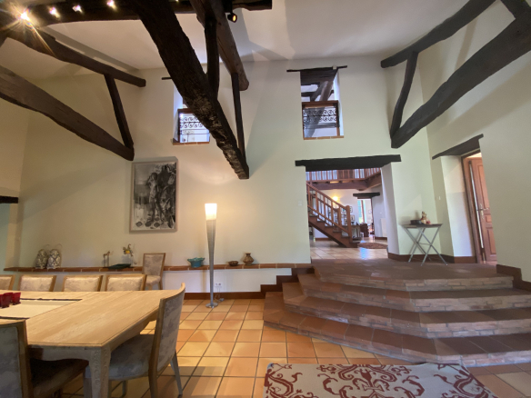 Interior of a country house in Moissac with a spacious living room and exposed beams.
