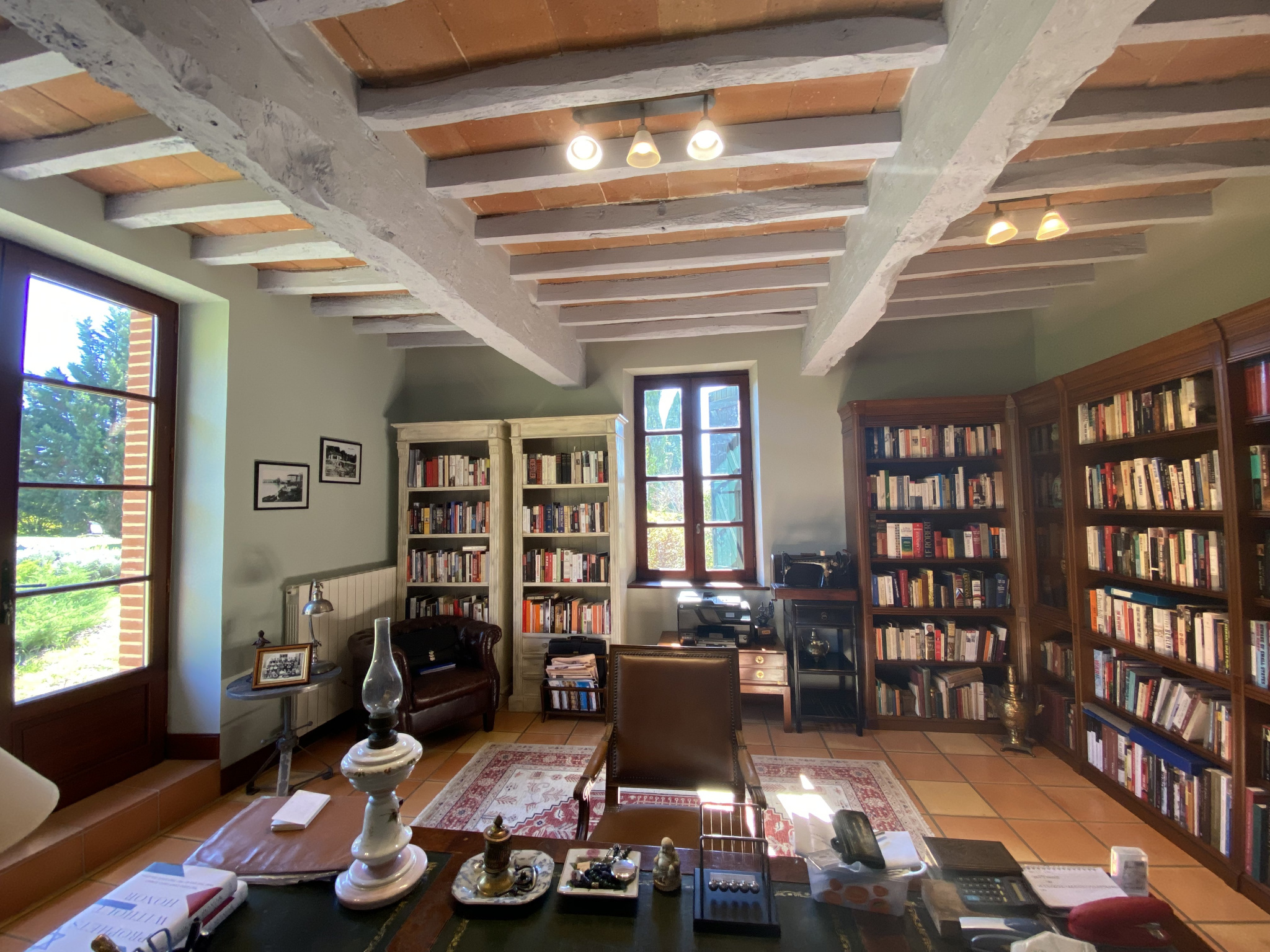 Office of a country house in Moissac Interior of an office with shelves filled with books and a wooden desk, natural light through the windows.