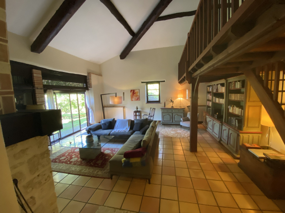 Interior of a country house with a spacious living room and library.