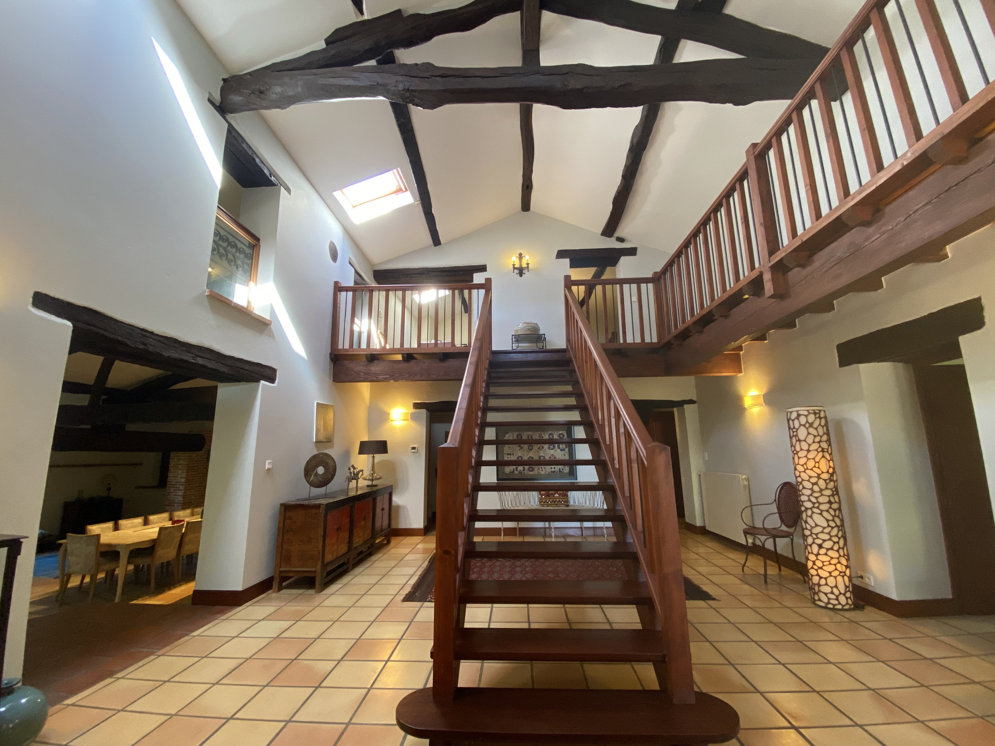 Interior of a country house in Moissac Interior of a country house with a wooden staircase and exposed beams.