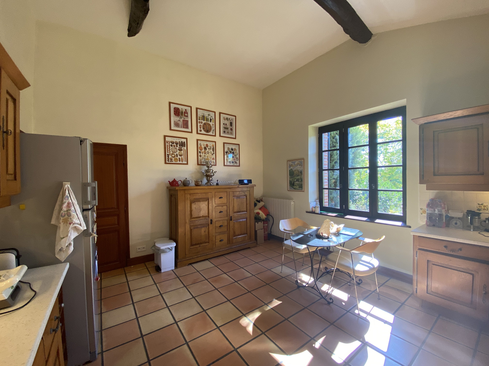 Kitchen of a country house in Moissac Bright kitchen in a country house with wooden furniture and large windows.