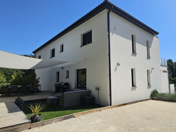 Villa contemporaine avec terrasse à Clermont-l'Hérault, entourée de verdure.