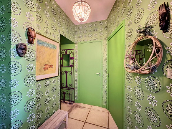 Entrance to a winemaker's house with green decor and artistic elements in Saint-Georges-d'Orques.
