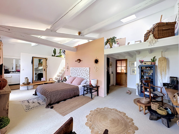 Interior of a winemaker's house in Saint-Georges-d'Orques, with a bed, decorative furniture and a bright space.